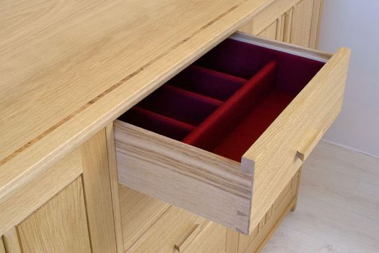 wooden drawer open with red felt lining 